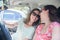 Young female persons best friends having fun at car road trip moment transportation concept and urban ordinary life with women