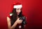 Young female photograph made the photo and looking in camera short with excited face and open mouth on red background in santa cl