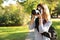 Young female photographer taking photo with professional camera in park