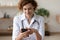 Young female physician using mobile app consulting remote patient online