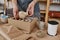 Young female pitcher or owner of small pottery shop putting clay jug into box