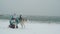 Young female playing and runing with siberian husky dog on the beach at snow storm, slow motion