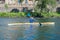 Young female practicing canoeing riding in her canoe navigating the Jerte river, Spain