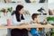 Young female psychologist working with little child in office