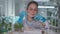 A young female researcher in a white gown examining a soil sample. Microbiologist analyzes ground for seedlings in a