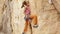 Young female rock climber trying to climb on a cliff, searching, reaching and gripping hold.