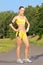 Young female runner posing on a running track in park