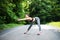 Young female runner stretching arms before running. Woman warming before workout in the park