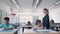 Young female school teacher walking between desks