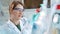 Young female scientist checking test tubes in the lab. Woman wears protective goggles