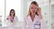 Young female scientist chemist biologist working in laboratory brings a glass flask to face and looks into camera