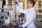 A young female scientist using an apparatus for the experiment at the university laboratory. Science, chemistry, lab, people