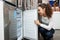 Young female selecting domestic refrigerator