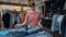 Young female seller in a denim store flips through a stack of denim pants