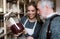 Young female shop assistant serving a senior man in a zero waste shop.