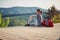 Young female sitting on viewpoint high in mountain, observing nature and smiling. nature, relaxing, positive energy concept