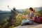 Young female sitting at viewpoint high in mountain taking  selfie. nature, relaxing, positive concept