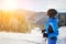 Young female skier against ski lift and winter mountains background