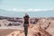 Young female solo traveler walking in hiking trail at Atacama Desert. Single Blond Caucasian girl explore Moon Valley in Chile