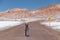 Young female solo traveler walking in hiking trail at Atacama Desert. Single Blond Caucasian girl explore Moon Valley in Chile