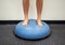 Young female standing on a bosu ball for a workout