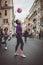 Young female street entertainer performing with her football in the streets of Rome