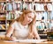 Young female student doing assignments in library