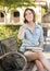 Young Female Student Outside Using Cell Phone Sitting on Bench