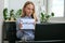 Young female teacher sitting at desk and using laptop showing HOMEWORK text at home. e Education Back to school. Student