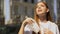 Young female teenager suffering city heat, waving napkin, trying to cool down