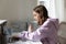 Young female teenager treating computer keyboard with antibacterial spray.