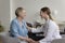 Young female therapist tells positive prognosis to happy senior woman