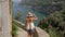 Young female tourist admires the beautiful view of the sea and mountains. Summer in Italy.