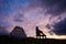 Young female tourist enjoying breathtaking sunset near tent in mountains in Romania