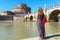 Young female tourist looks at the Castel Sant`Angelo in Rome