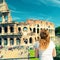 Young female tourist looks at the Colosseum in Rome