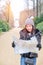 Young female tourist with map looking for a way to Sans Souci palace in Potsdam, Berlin, Germany, Europe