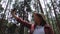 Young female tourist takes off her medical mask while backpacking with enjoying nature in the forest.Women hikers using her mobile