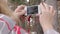 Young female tourist takes pictures old ethnic village on her smartphone