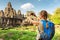 Young female tourist taking picture of Bayon temple in Angkor