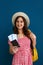 Young female tourist with tickets and passport on color background