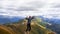 A young female tourist on top of a mountain jumps into the sky. Happiness and a sense of freedom,