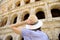 Young female traveler looking on famous the Colosseum in Rome