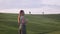 Young female traveler taking photo of a beautiful Tuscany landscape in sunset