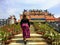 A young female traveler walking up the steps towards the Guan Im Sutham Temple in Kanchanaburi, Thailand.