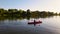 Young female traveller floats in kayak on river at warm ening sunlight