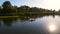 Young female traveller floats in kayak on river at warm ening sunlight