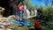 Young female traveller looking to the waterfall and rising up her hands in the jungles. Two colorful parrots sitting