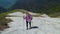 young female traveller is walking at top of mount and smiling, hiking and exploring