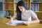 Young female university student concentrate doing language practice examination inside library